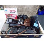 A vintage luggage case containing Boots Fleet 15x35 binoculars, assorted vintage cameras.