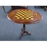 A 19th century mahogany tilt top chessboard occasional table on three way pedestal.