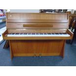 A Chappell teak cased overstrung mini piano with storage stool.