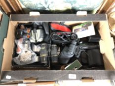 A box containing antique and later field glasses including Super Zenith, assorted cameras,