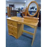 A pine three drawer single pedestal dressing table with mirror and stool together with matching