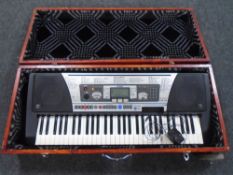 A Yamaha PSR-350 electric keyboard with lead in a wooden case.