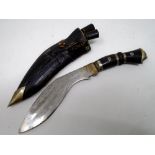 A Kukri knife in leather sheath.