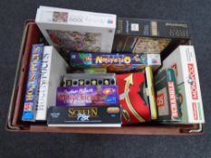A crate containing a quantity of board games and jigsaws including Operation, Monopoly,
