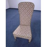 An Edwardian bedroom chair upholstered in brocade fabric.