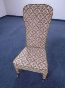 An Edwardian bedroom chair upholstered in brocade fabric.