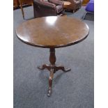 A 19th century oak tilt top pedestal occasional table.