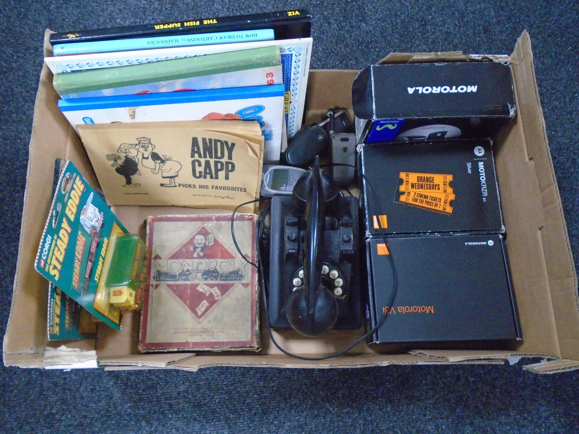 A box containing vintage bakelite telephone handset, Monopoly game,