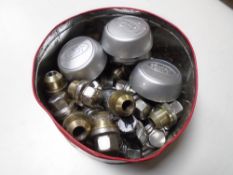 A tin containing Land Rover wheel nuts and centre caps.