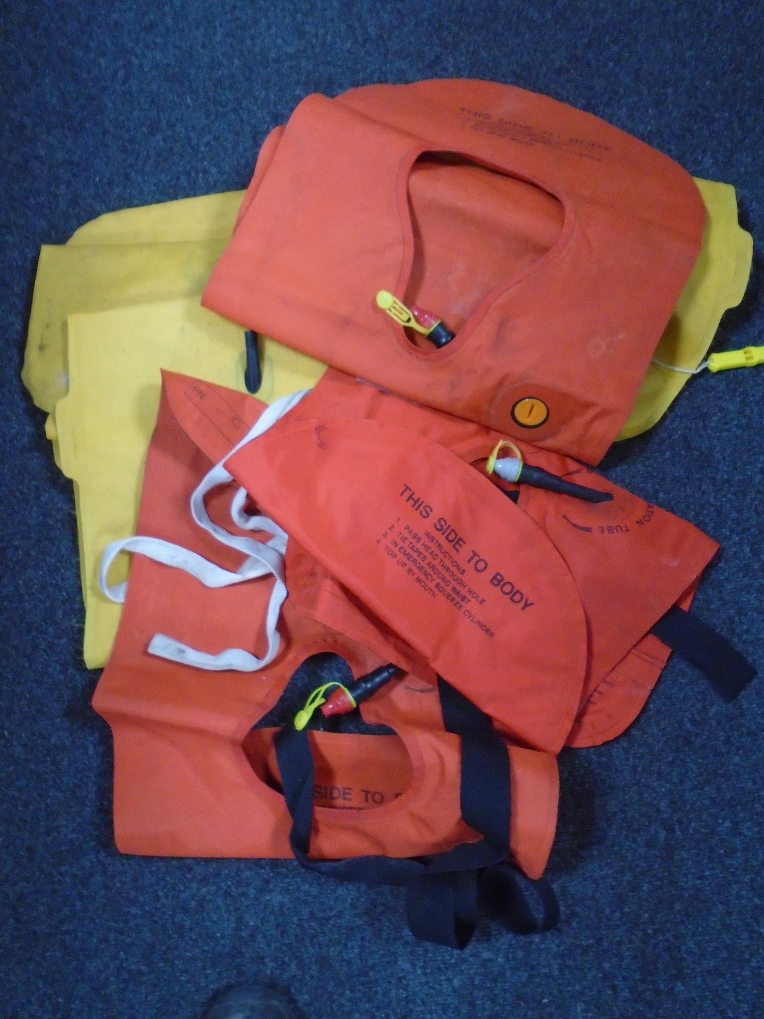 A box containing three self inflating life jackets.