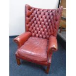 A red buttoned and studded leather Chesterfield wingback armchair.
