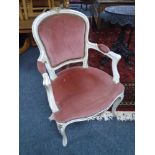 A French white and gilt salon armchair upholstered in pink dralon fabric.