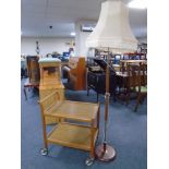 A 20th century teak two tier coffee table together with a teak and brass standard lamp with shade.