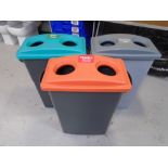 Three plastic recycling bins.