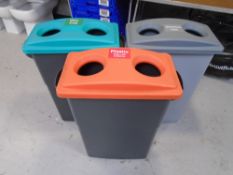 Three plastic recycling bins.