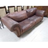 A brown leather scroll arm settee.