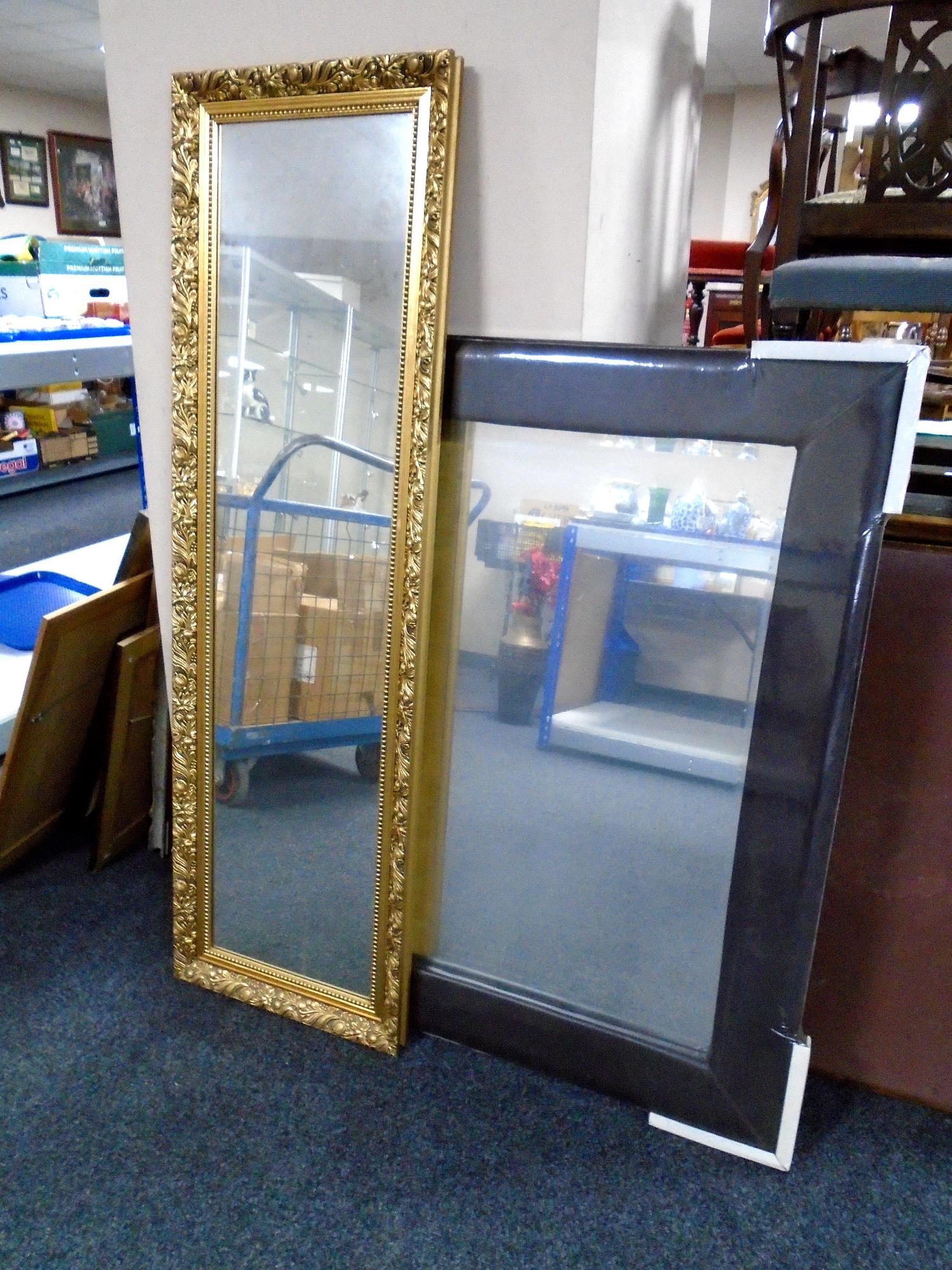 A contemporary bevel edge mirror in brown leather frame and a gilt framed hall mirror.