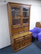 An Ercol Grasmere double door cocktail display cabinet fitted with cupboards and drawers beneath,