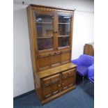 An Ercol Grasmere double door cocktail display cabinet fitted with cupboards and drawers beneath,