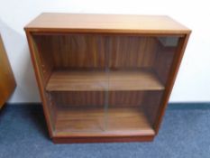 A 20th century teak sliding glass door bookcase,