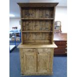 A Victorian pine farmhouse kitchen dresser fitted with cupboards and drawers beneath,