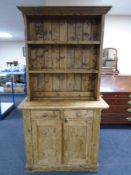 A Victorian pine farmhouse kitchen dresser fitted with cupboards and drawers beneath,