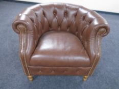 An Alexander & James buttoned and studded leather tub armchair.