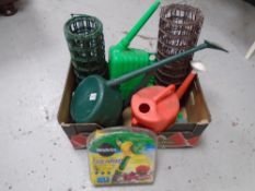 A box containing three plastic watering cans,