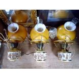 Three ceramic hanging oil lamps with amber shades and chimneys depicting Grecian figures.