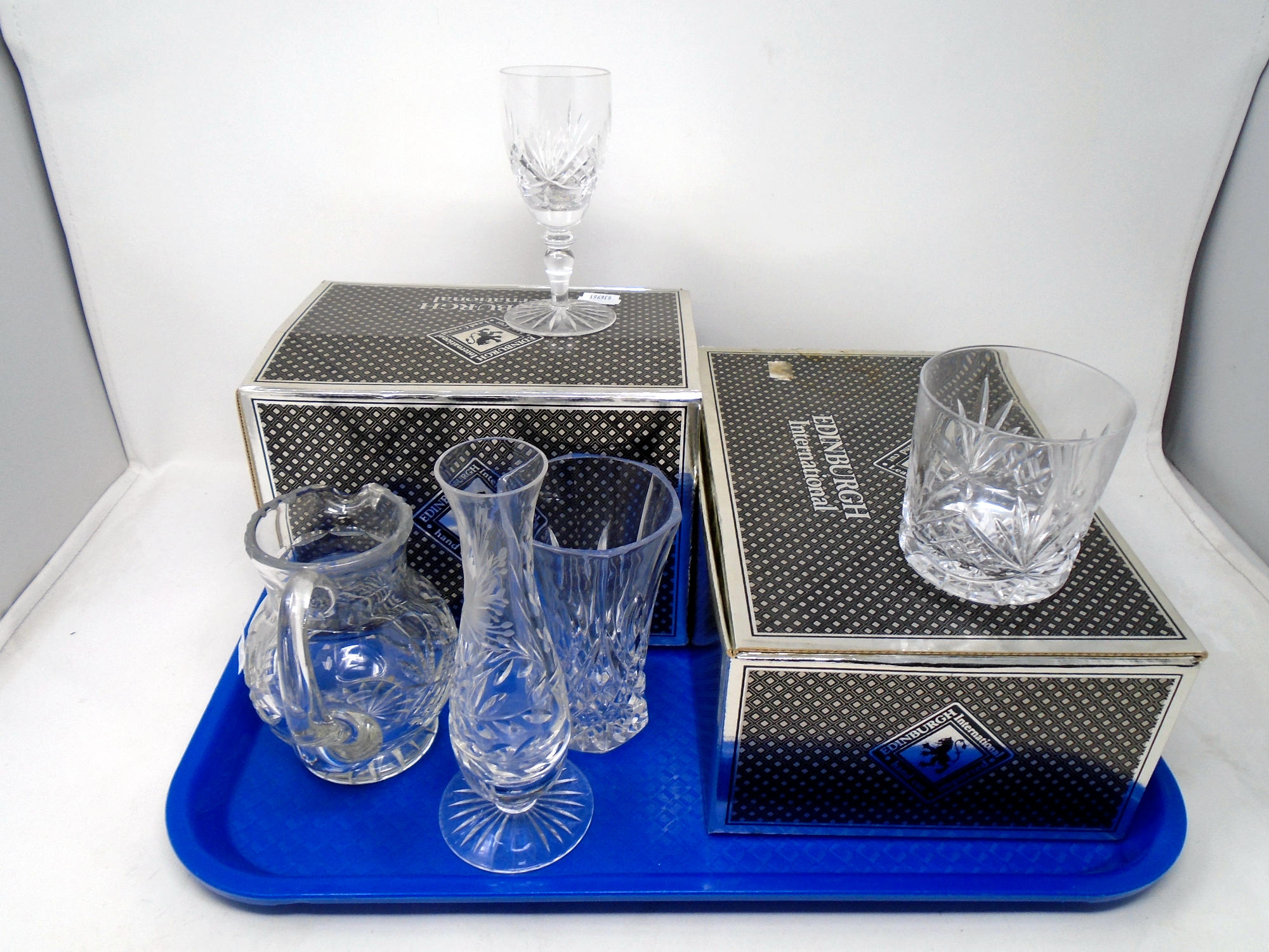 A tray containing two sets of Edinburgh International crystal tumblers and wine glasses together