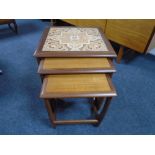 A nest of three mid-20th century teak G-Plan tables one with tiled inset panel.