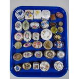 A tray containing a collection of metal and porcelain trinket boxes.