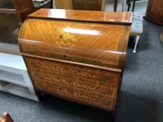 A reproduction marquetry inlaid barrel fronted bureau fitted with three drawers.