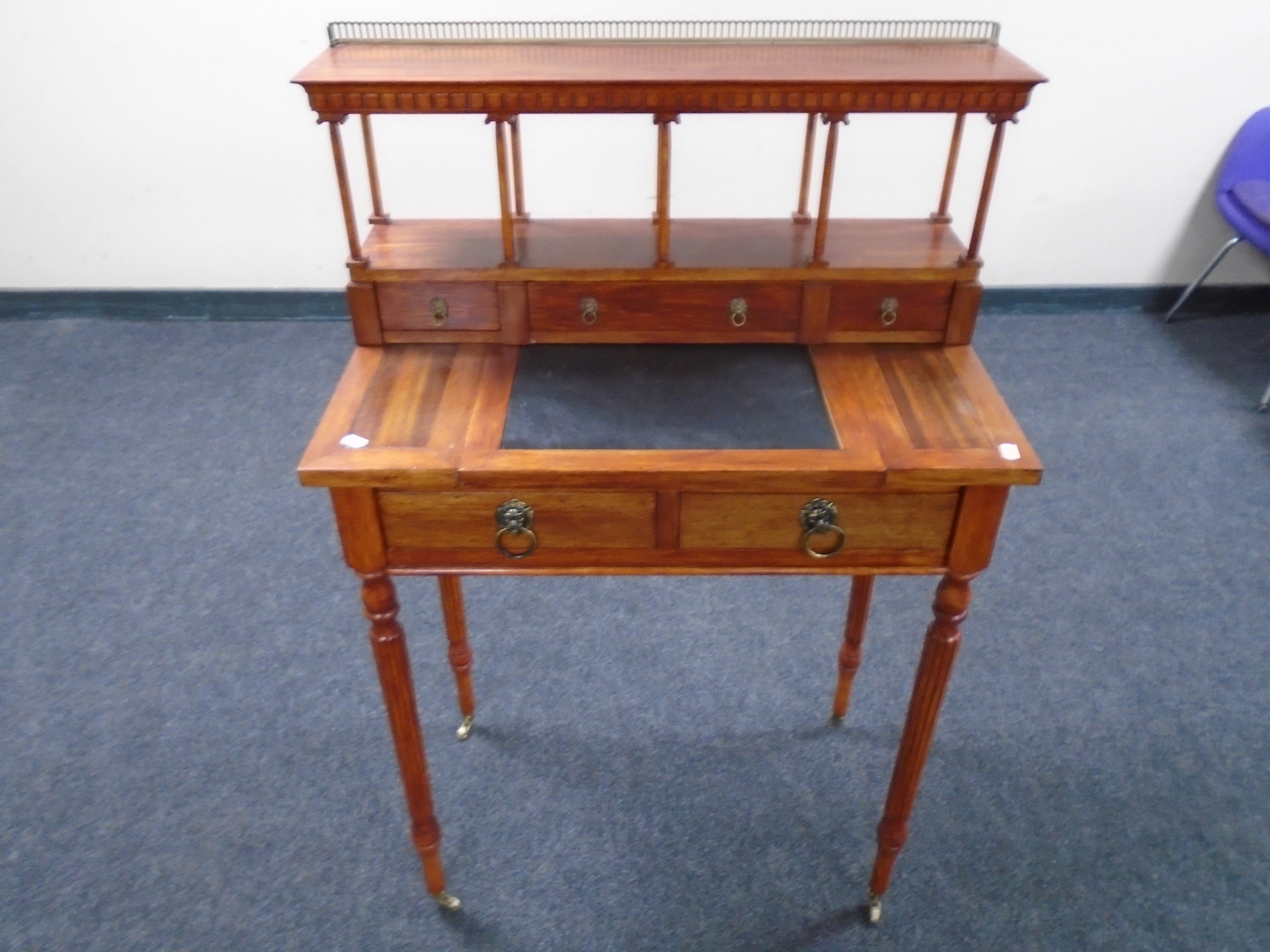 A reproduction lady's writing table on reeded legs with galleried top.