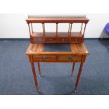 A reproduction lady's writing table on reeded legs with galleried top.