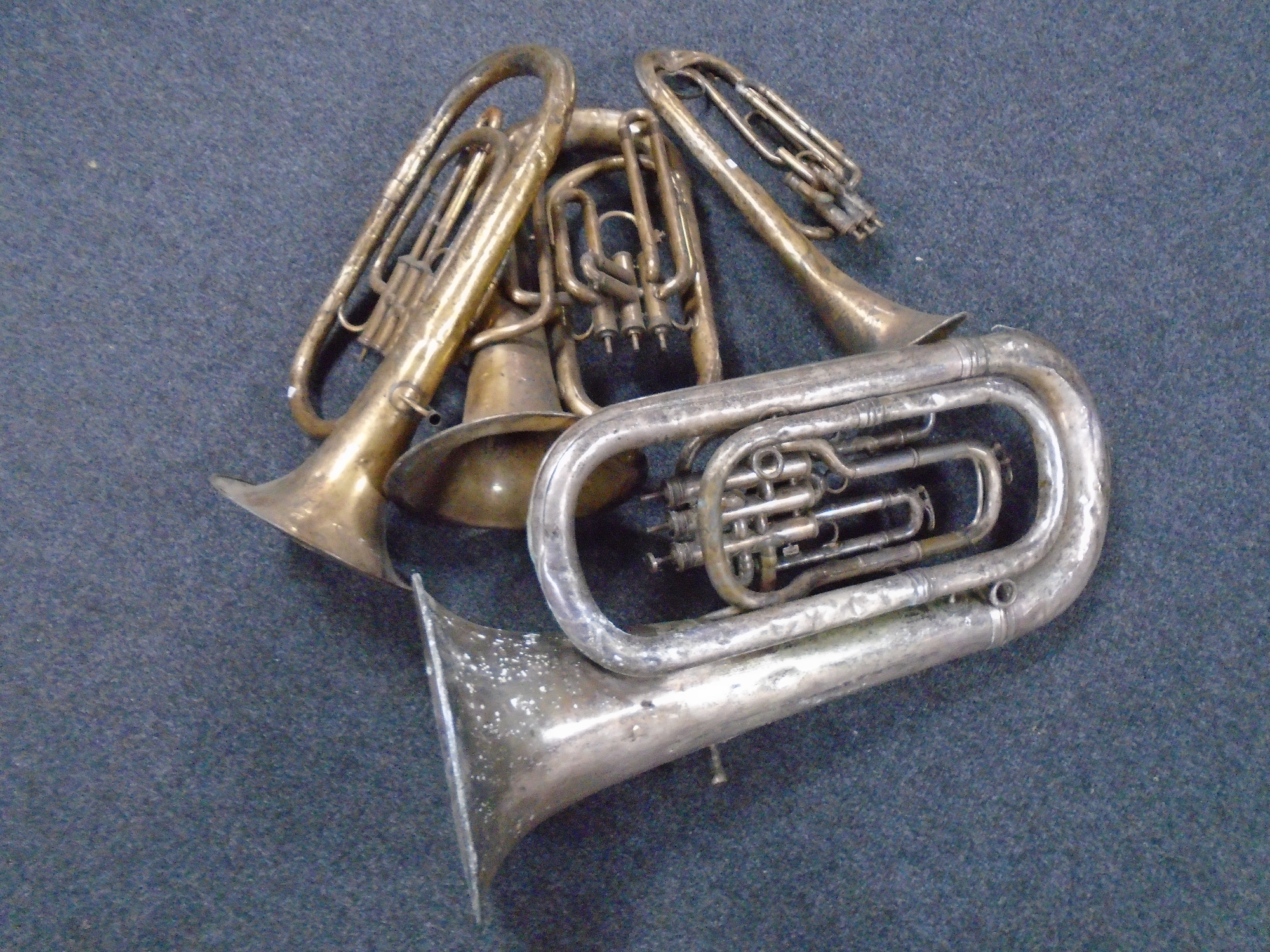 A box of brass wind instruments including tuba etc.