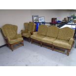 An Ercol elm and beech wood framed three piece lounge suite comprising of a three seater settee and