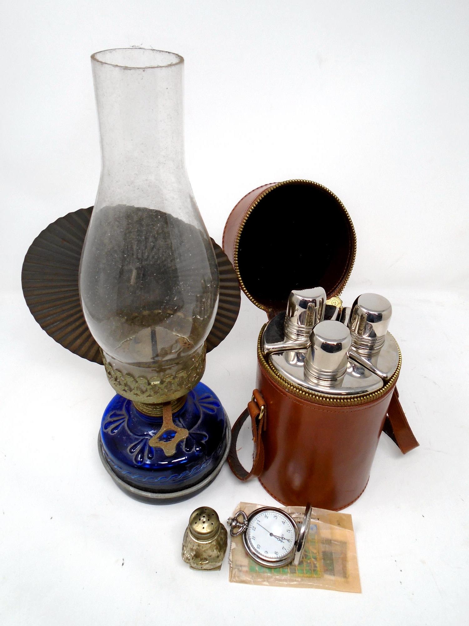 A set of three glass travel flasks in leather carry case together with oil lamp,