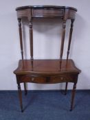 A mahogany serpentine fronted turnover top table fitted with leather inset panel and two drawers