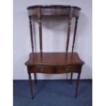 A mahogany serpentine fronted turnover top table fitted with leather inset panel and two drawers