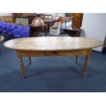An antique pine oval farmhouse kitchen table fitted with a drawer,
