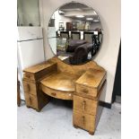 A burr walnut Art Deco dressing table fitted with seven drawers and circular mirror.