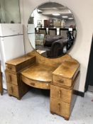 A burr walnut Art Deco dressing table fitted with seven drawers and circular mirror.