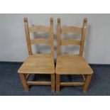 A pair of pine ladder back chairs.