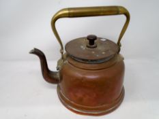 An antique copper kettle with brass handle.