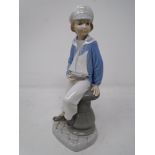 A Lladro figure of a boy in sailor suit with pond yacht.