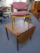 A mid-20th century teak flap sided dining table together with an elbow chair (both parts AF)