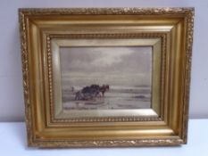 An early 20th century gilt framed oil-on-canvas depicting a figure with a horse and cart,