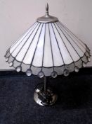 A contemporary chrome metal table lamp with leaded glass shade