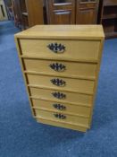 A continental six drawer chest with metal handles.